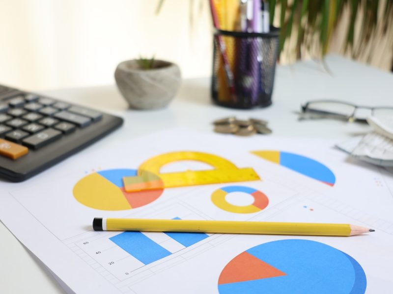 A desk with a calculator and printed rental figures