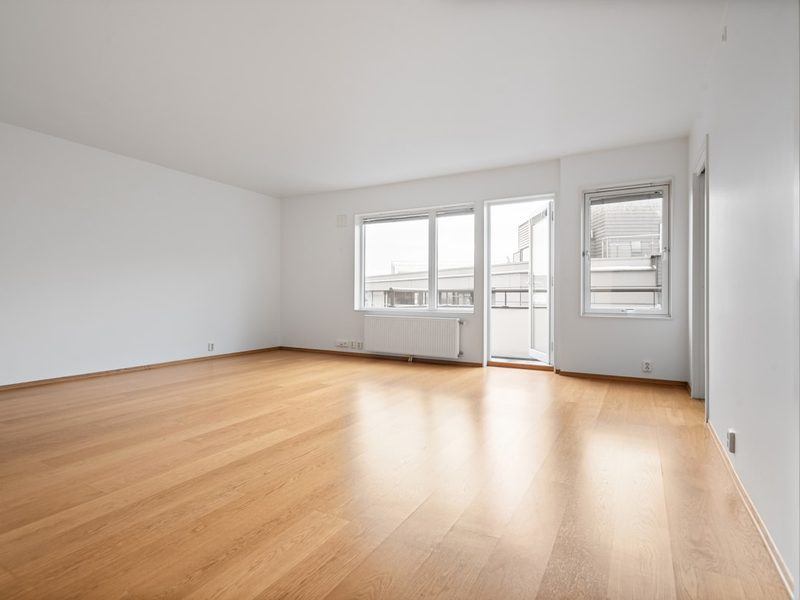 A bright, empty apartment with a balcony door, ready to let